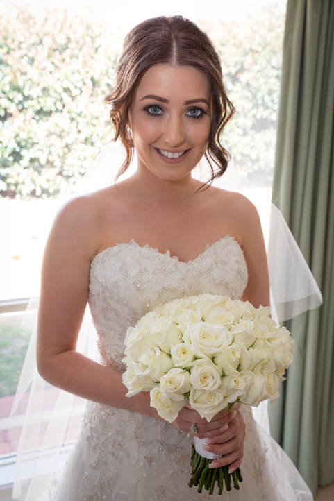 Our bride at home before the ceremony holding her wedding bouquet